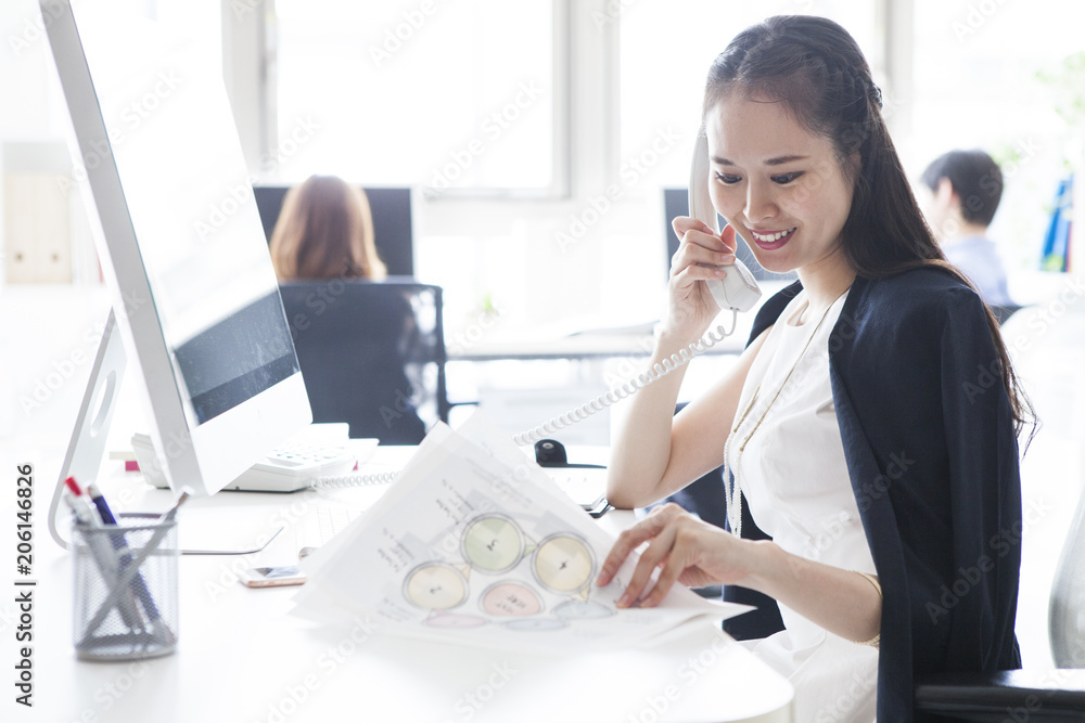 女性はオフィスで電話している