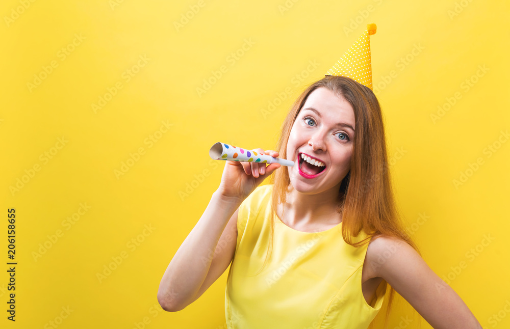 Young woman with party theme on a yellow background