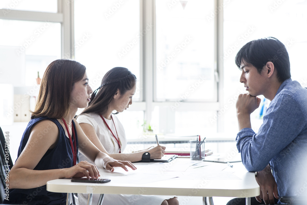 三人の若い会社員たちはミーティングしている