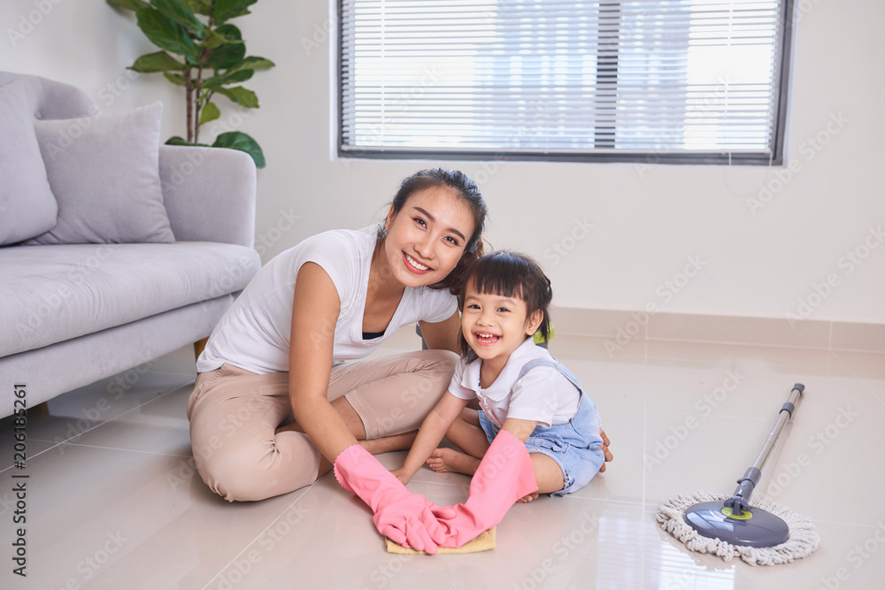 妈妈教女儿周末打扫家里的客厅。一个年轻女人和一个小孩g