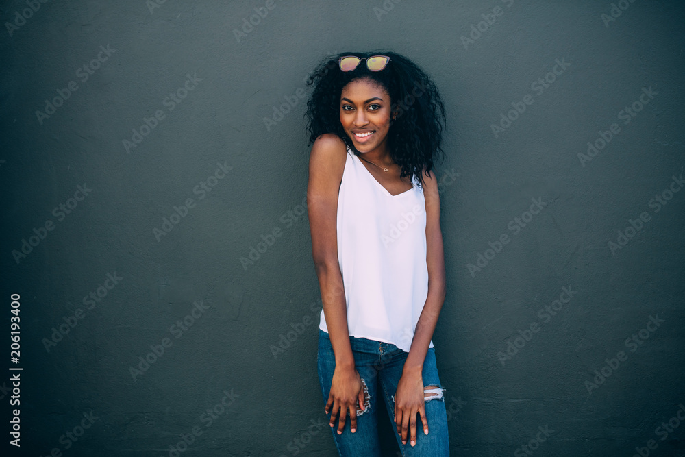 Portrait of a woman standing against a wall