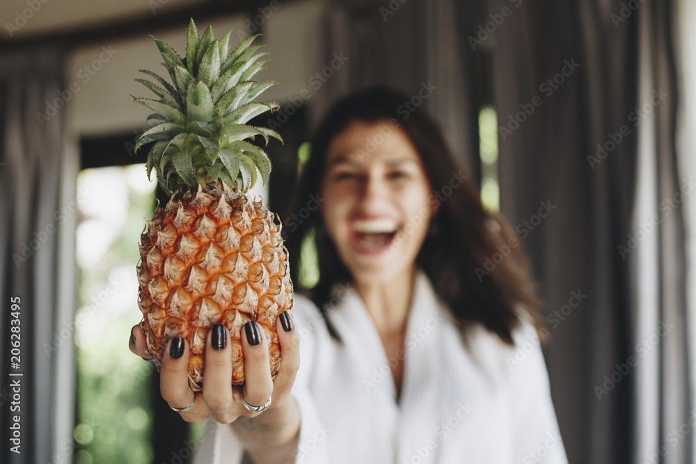 穿着浴袍拿着菠萝的女人