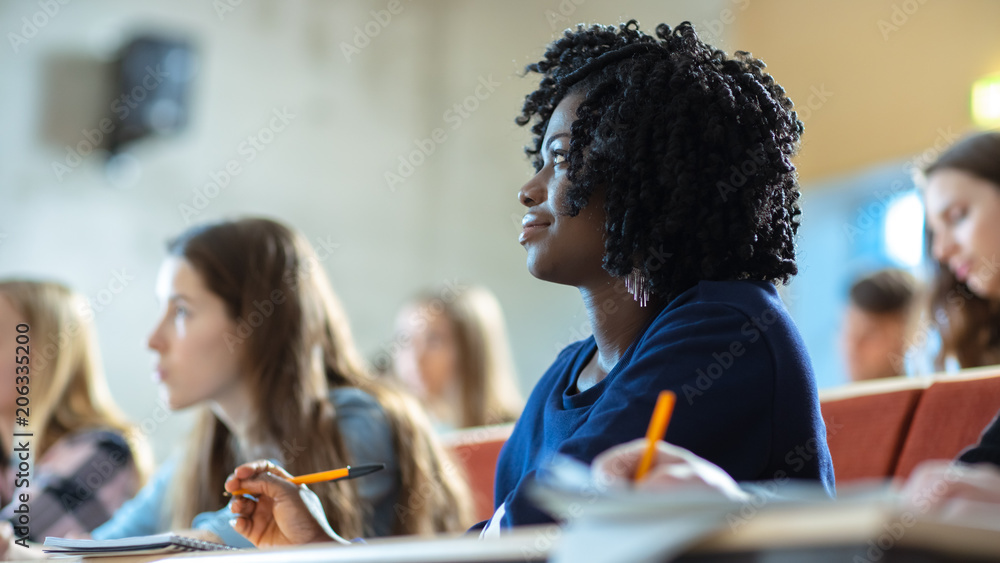 一位美丽的黑人女学生坐在教室里的同学中间的特写，她