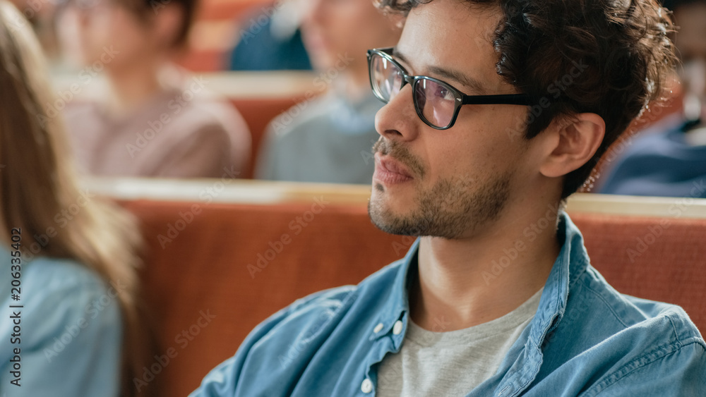 英俊潇洒的西班牙裔男子在满是多族裔学生的教室里听讲座。S