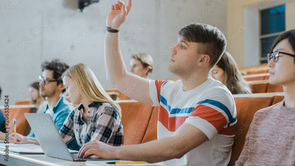 英俊的高加索学生在大学听讲座时使用笔记本电脑，他养了汉