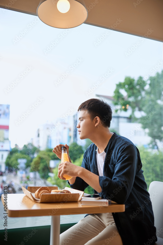 男人们坐在咖啡馆里喝果汁。思考和眺望远方