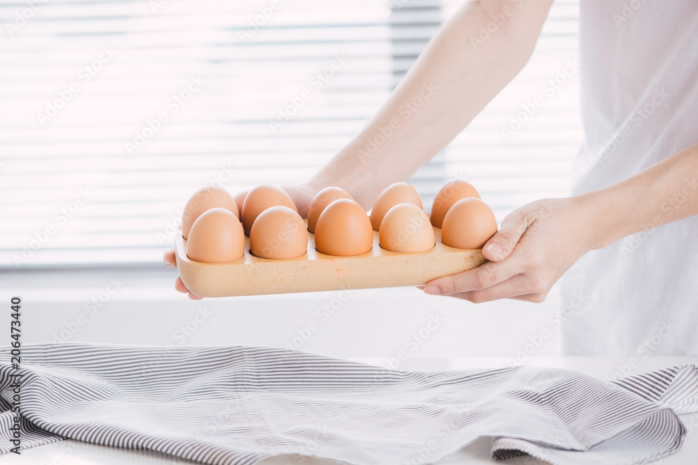 Female hands holding chicken eggs.