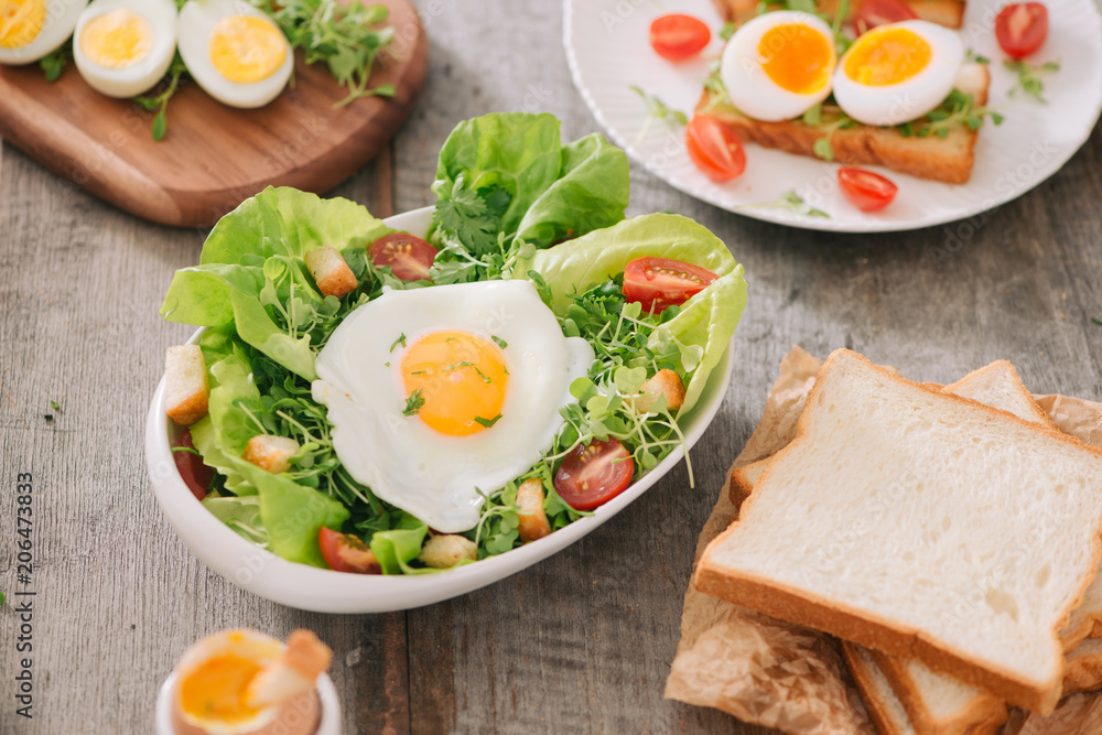 High Angle View of a Nutritious Vegetable Salad with Boiled Egg Slices, Served on a White Plate on T