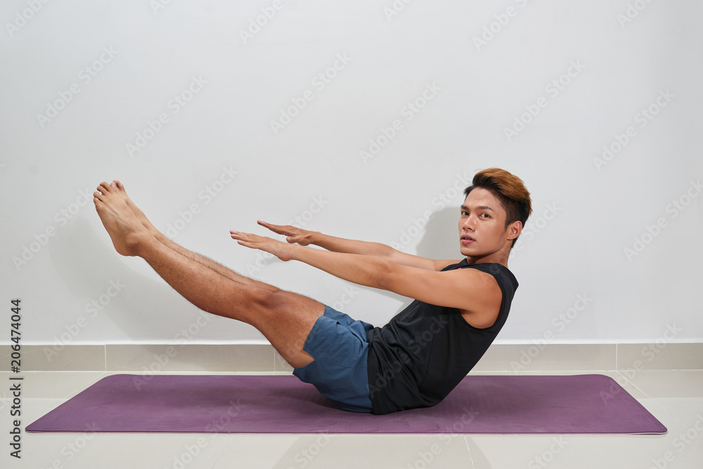 Young Man Exercising On Exercise Mat, Indoors