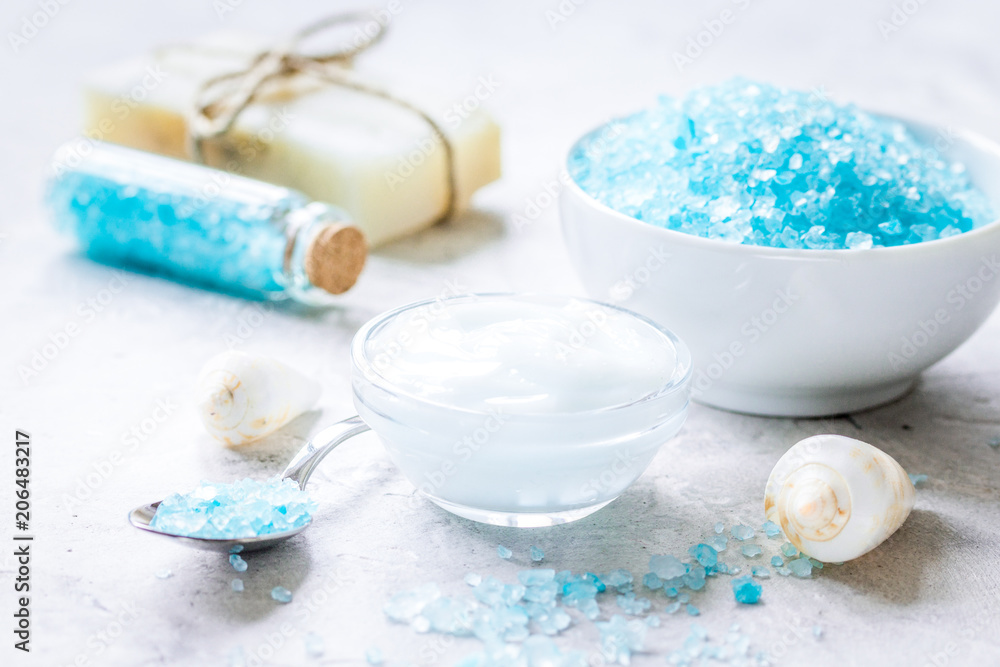 blue sea salt, soap and body cream on stone desk background