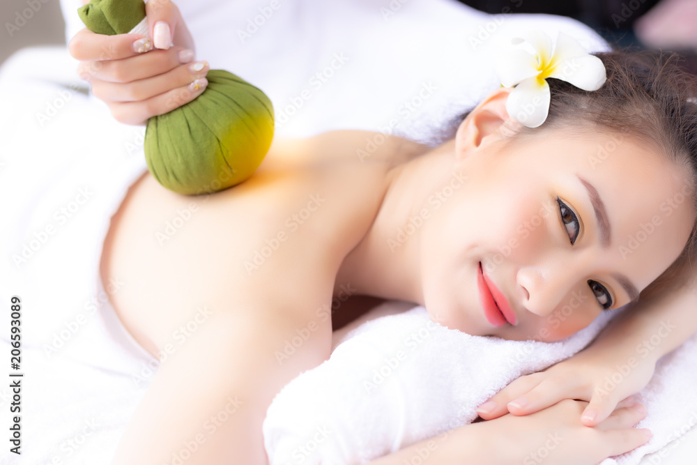 Massager rejuvenate and massage charming beautiful woman’s back by using herbal ball. Attractive gir