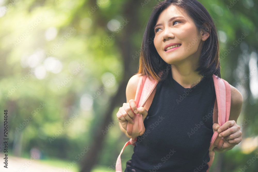 健康的亚洲女性在绿色公园背景下放松心情，周末度假