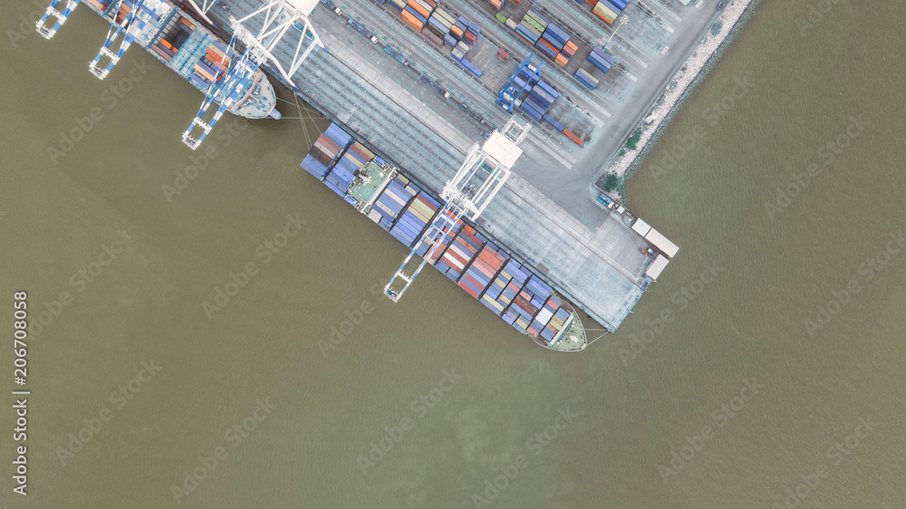 Container ship in export and import business and logistics. Shipping cargo to harbor by crane. Water