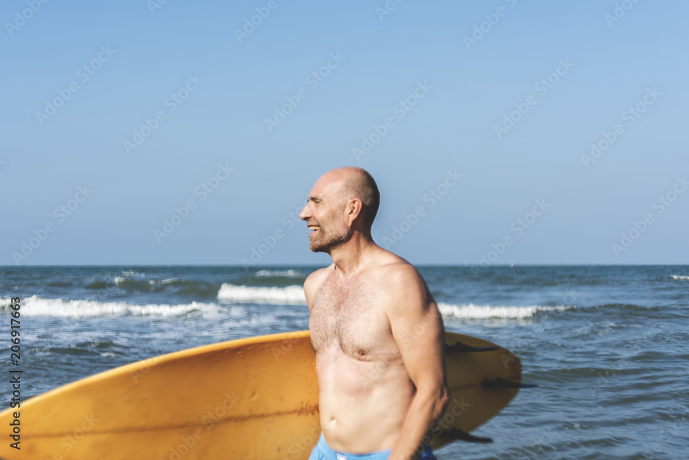 一名男子在海边拿着冲浪板