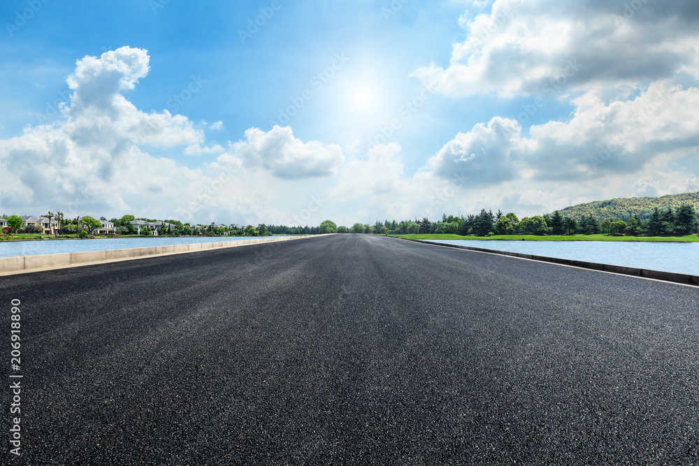 Asphalt road and apartment building with cloud landscape in the city suburbs