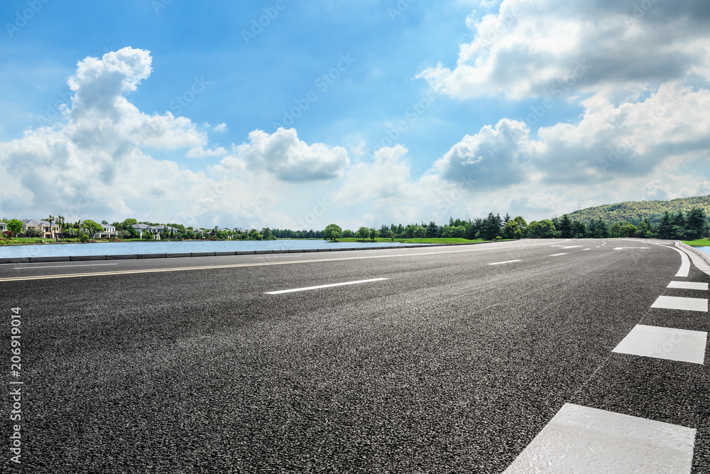 Asphalt road and apartment building with cloud landscape in the city suburbs