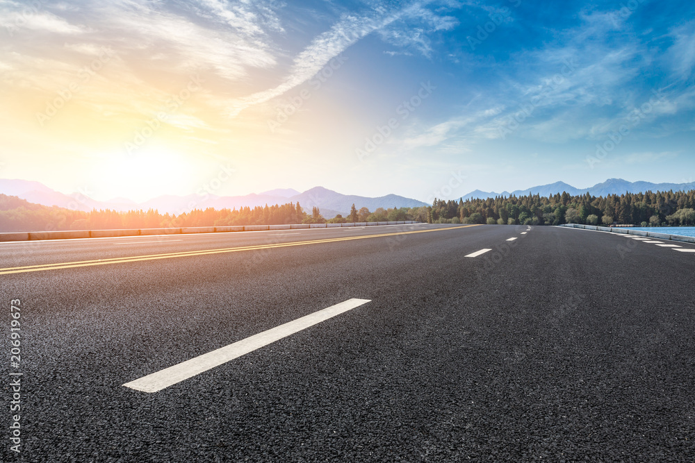 Asphalt road and hills with sky clouds landscape at sunset