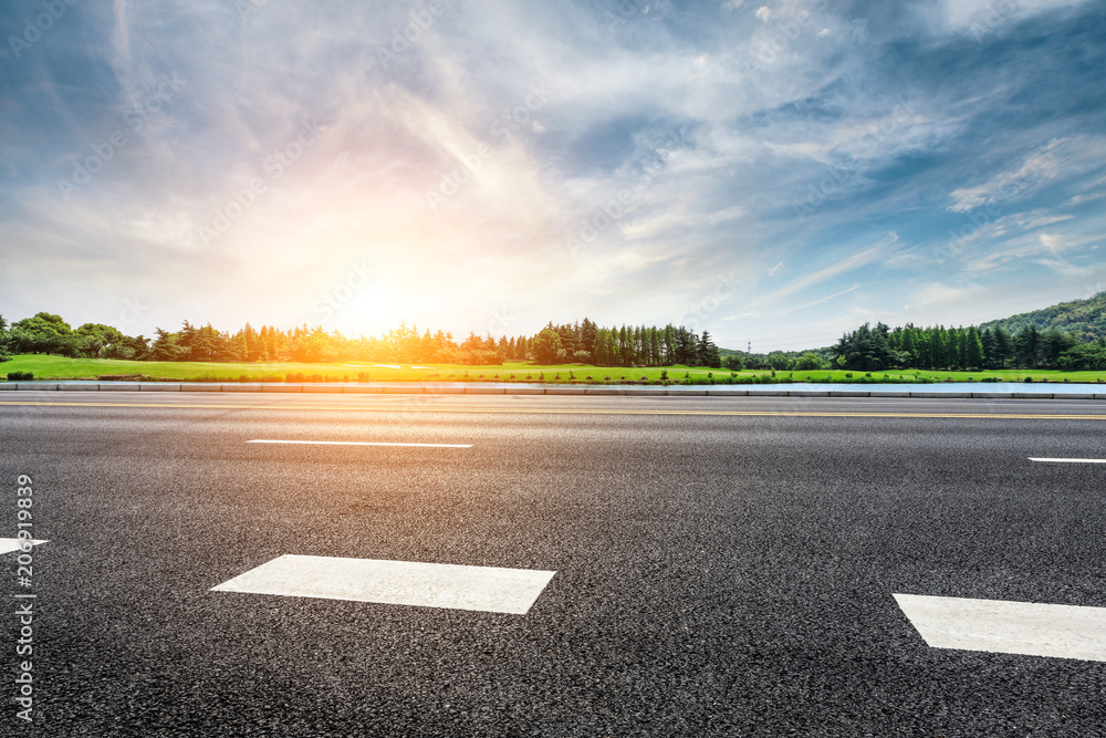 Asphalt road and forest with sky clouds landscape at sunset