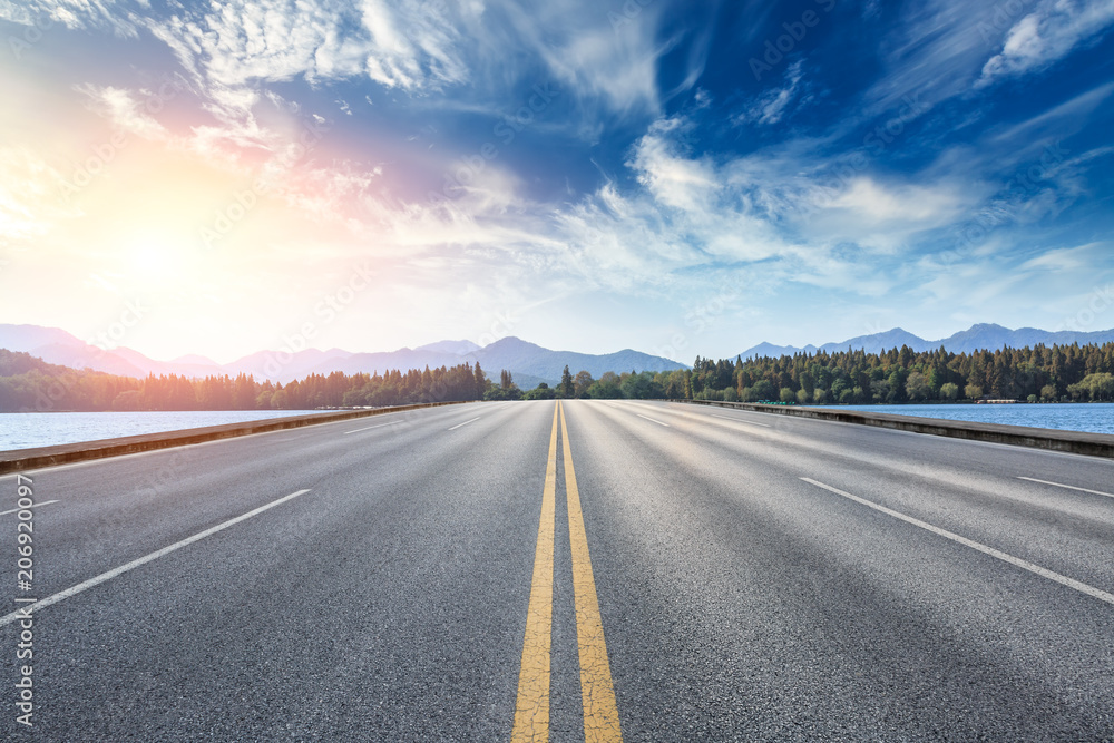 Asphalt road and hills with sky clouds landscape at sunset