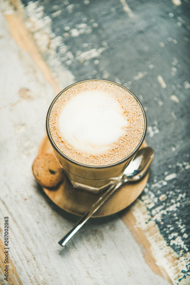 Latte coffee in glass over wooden textured background.