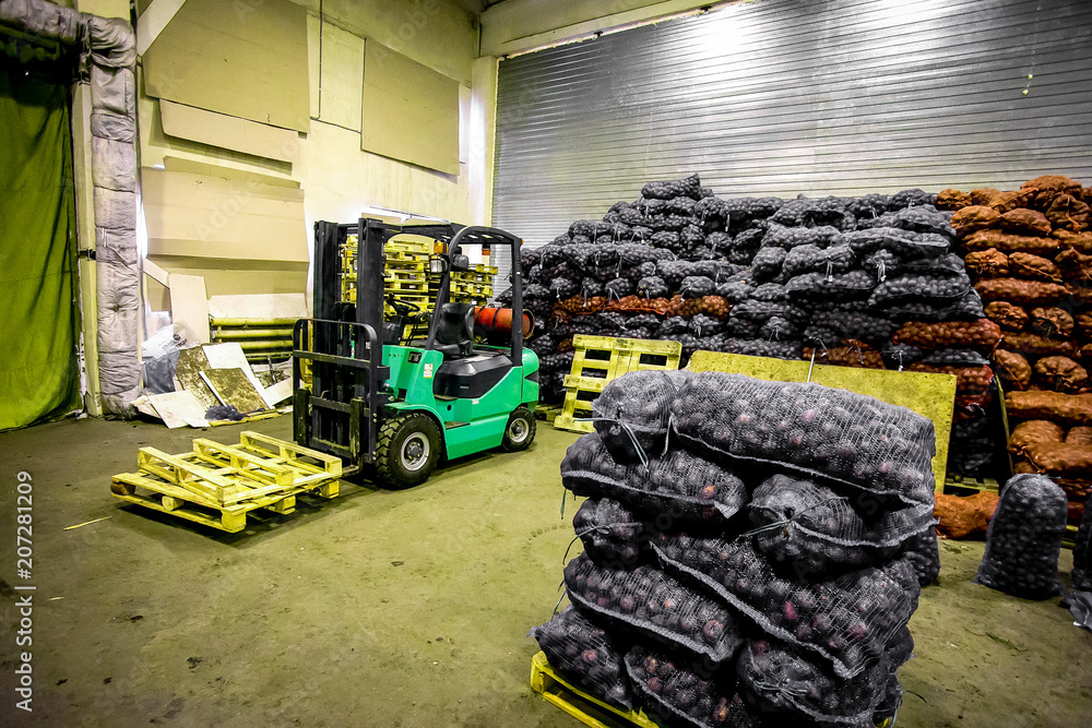 Bags and crates of potato in storage house