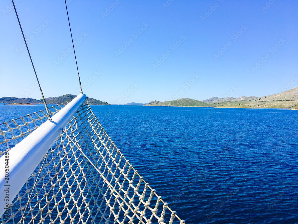 Sailing boat bow on open sea, with blue skies in summer