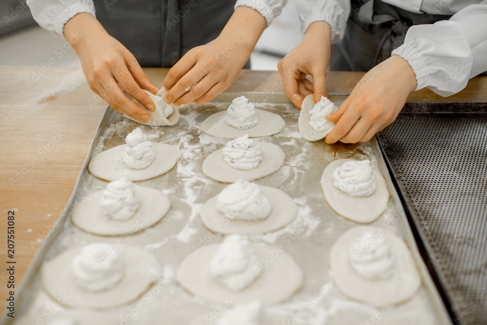 工人在制造厂用馅料制作生面包进行烘焙