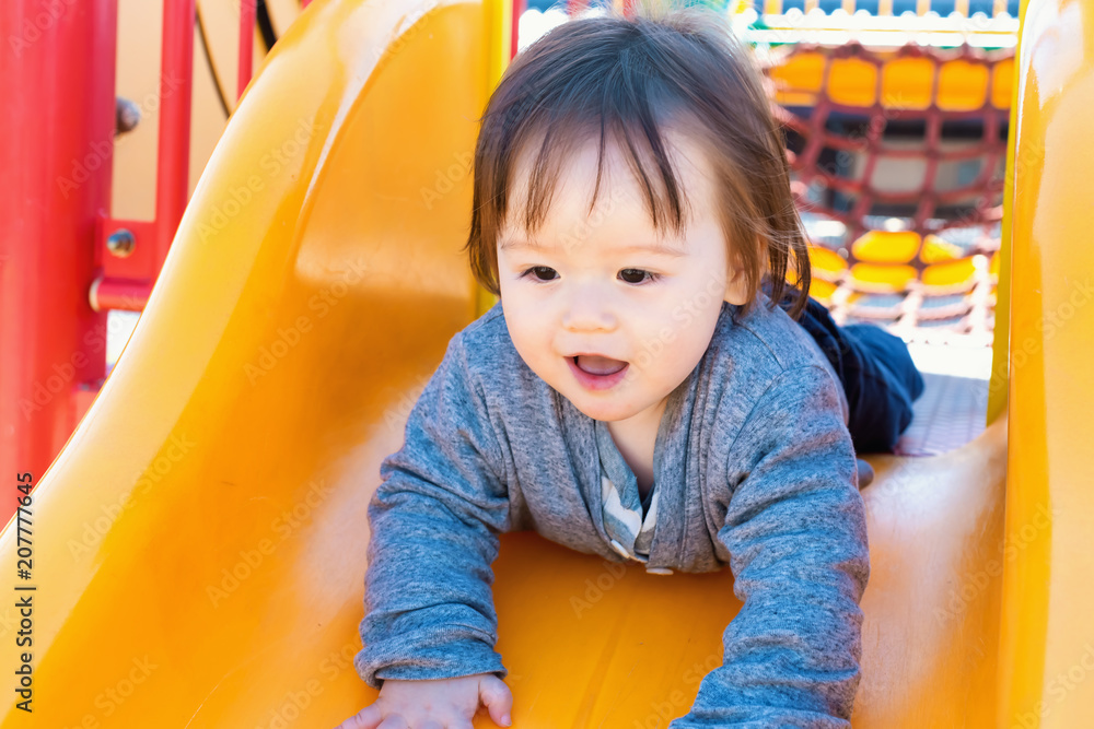 混血幼童在操场上玩滑梯