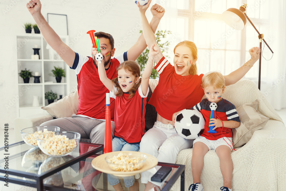 family of fans watching a football match on TV at home