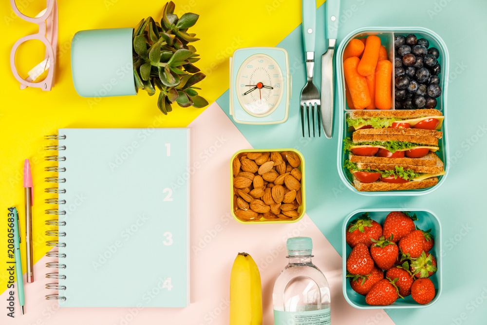 Creative flat lay with healthy lunch and office or school supplies