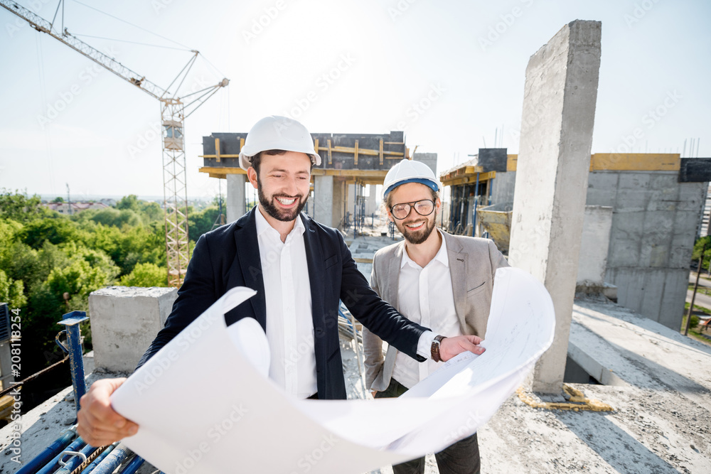 两位工程师或建筑师在施工期间一起绘制房屋图纸