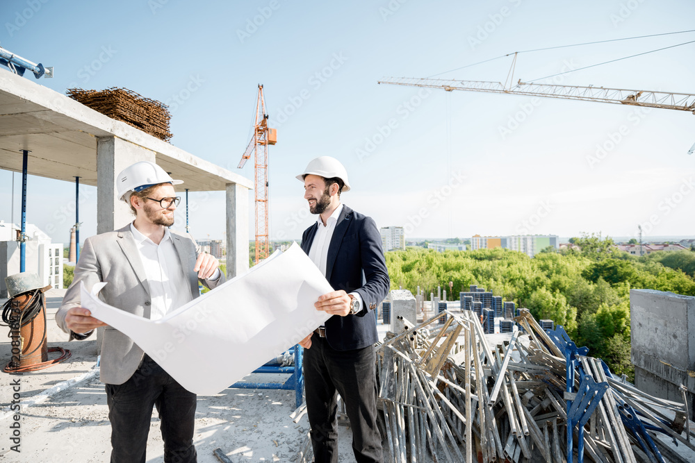 两名工程师或建筑师在施工期间一起绘制房屋图纸