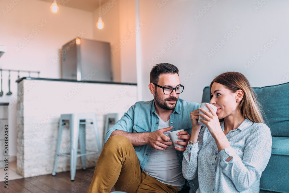 一对夫妇在公寓的地板上喝着茶或咖啡。