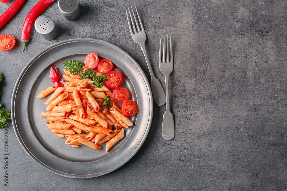 Plate of tasty pasta with tomato sauce on table, top view