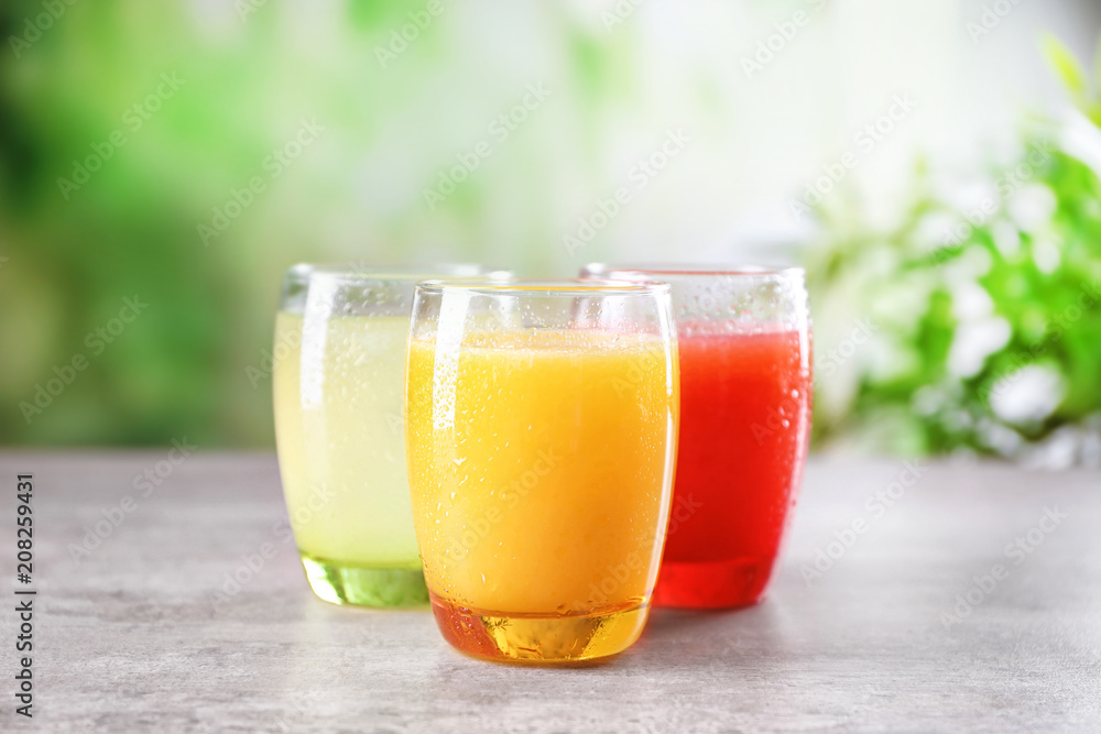 Glasses with different citrus juices on table