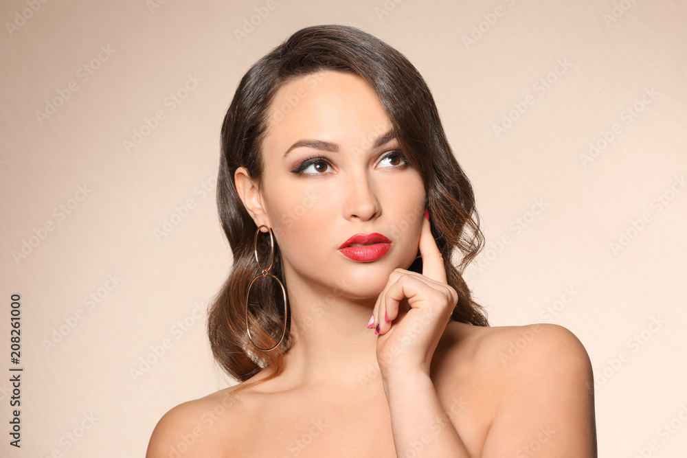 Portrait of young woman with beautiful professional makeup on color background