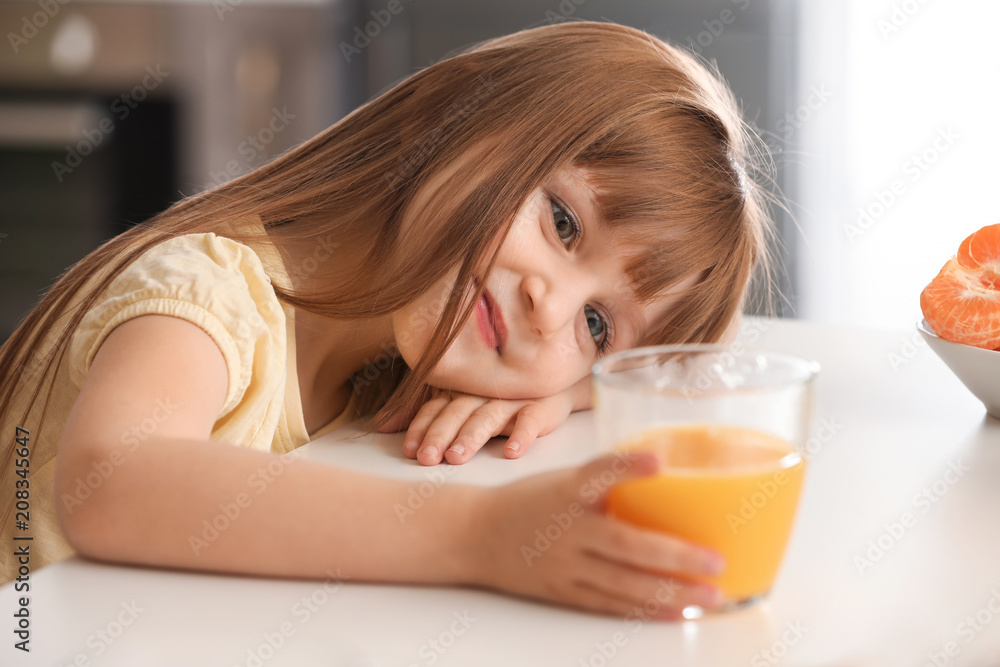 Funny little girl with citrus juice at home