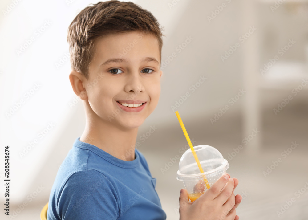 Funny little boy with citrus juice at home