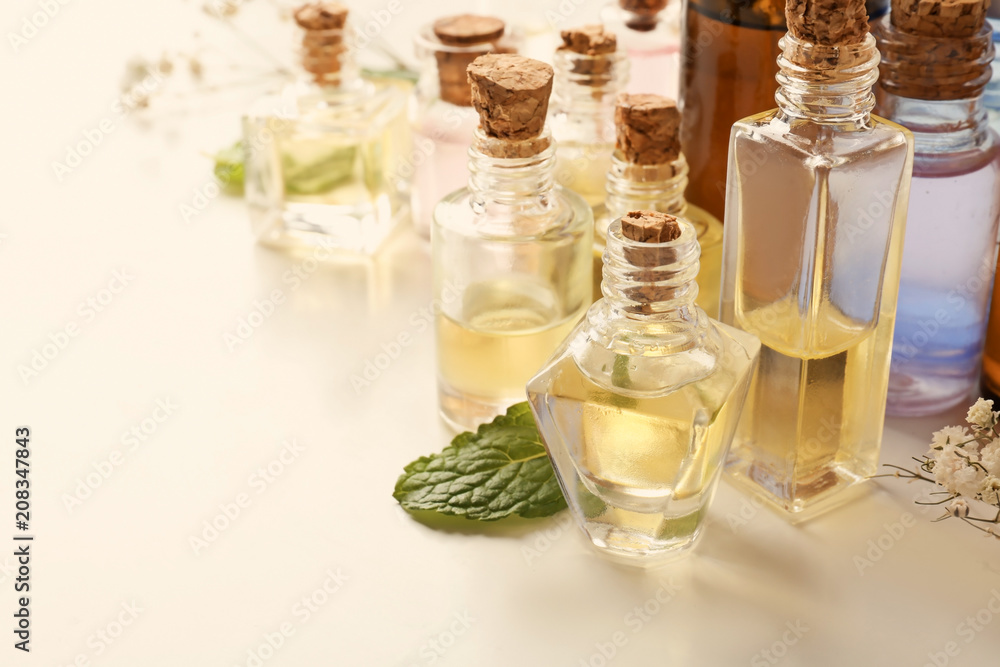 Bottles with essential oils on white background