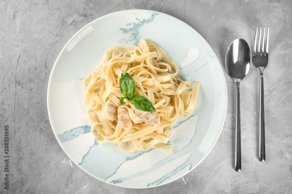 Plate of tasty pasta with chicken fillet on table, top view