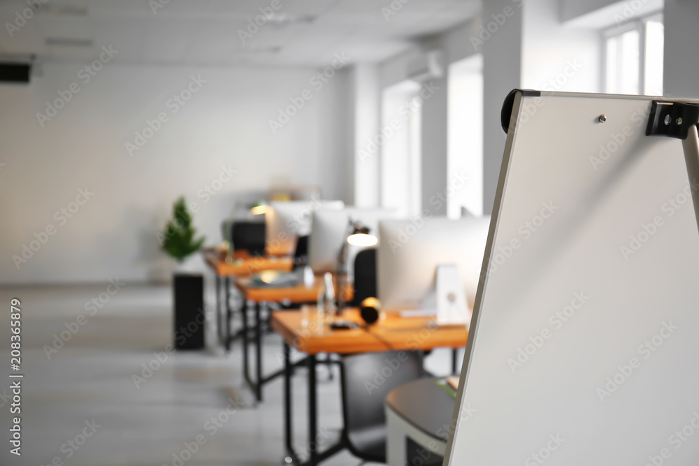 Office interior with tables, chairs and flip chart. Workplace design