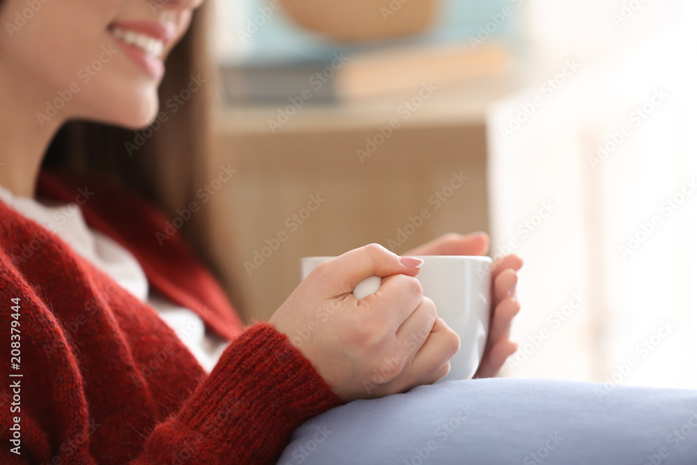 家里有一杯热茶的漂亮年轻女人