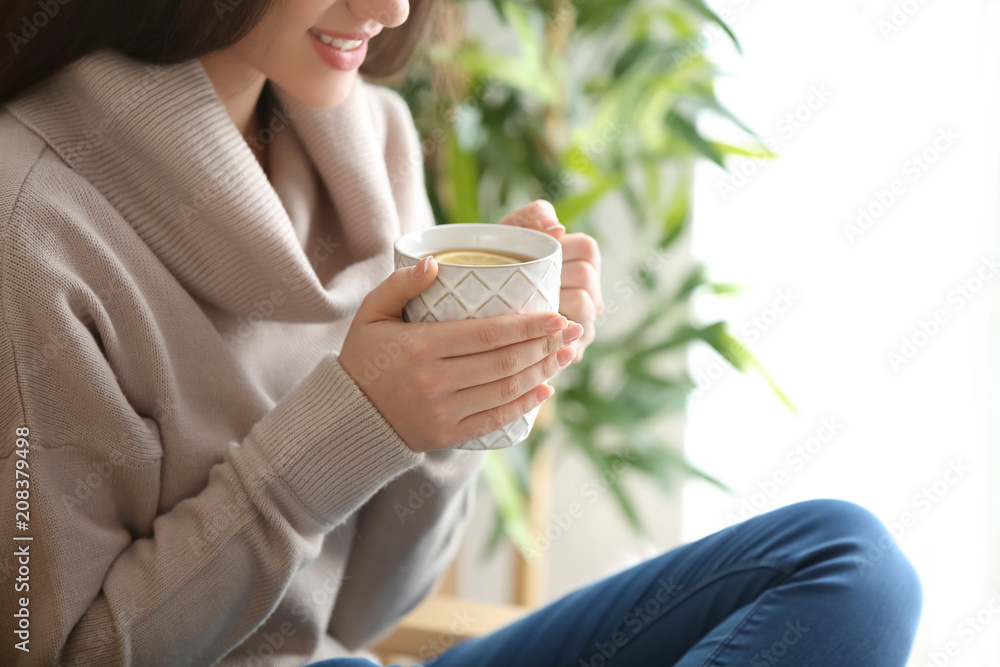 家里有一杯热茶的漂亮年轻女人