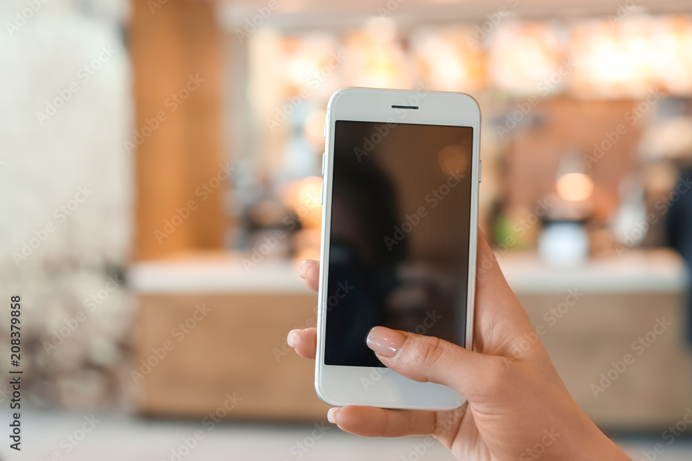 Woman with mobile phone ordering food delivery online at home