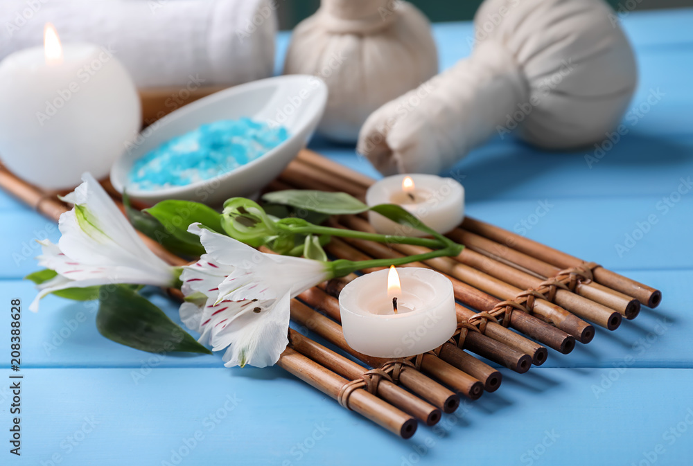 Beautiful spa composition with sea salt, flowers and candles on wooden table