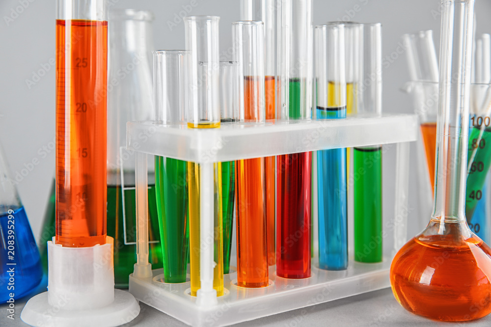 Test tubes with colorful liquids in holder, closeup