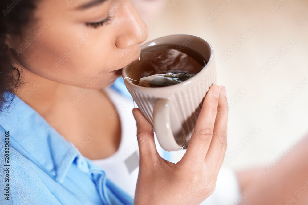 美丽的非裔美国女人在室内喝茶，特写