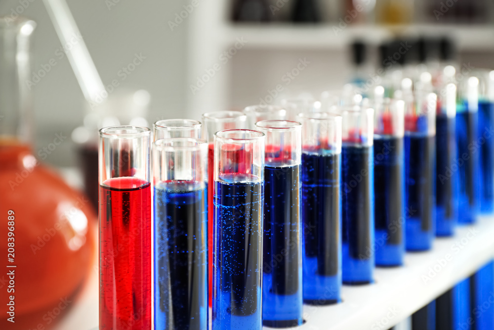 Test tubes with colorful liquids in holder, closeup