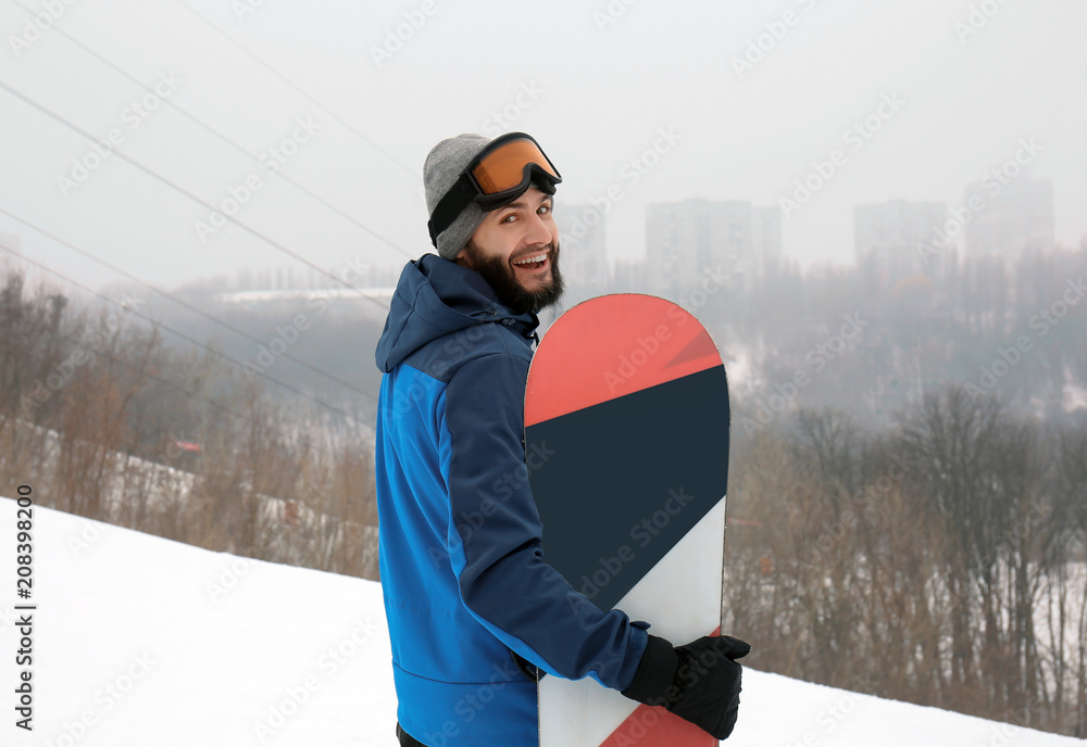 冬季度假区斜坡上的男单板滑雪运动员