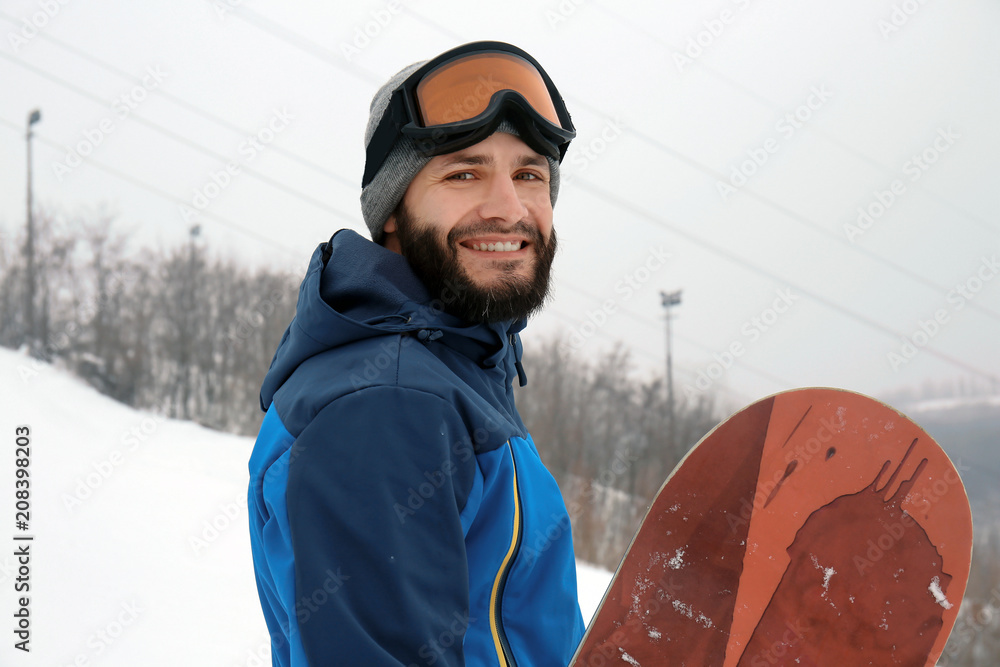 冬季度假胜地斜坡上的男单板滑雪运动员